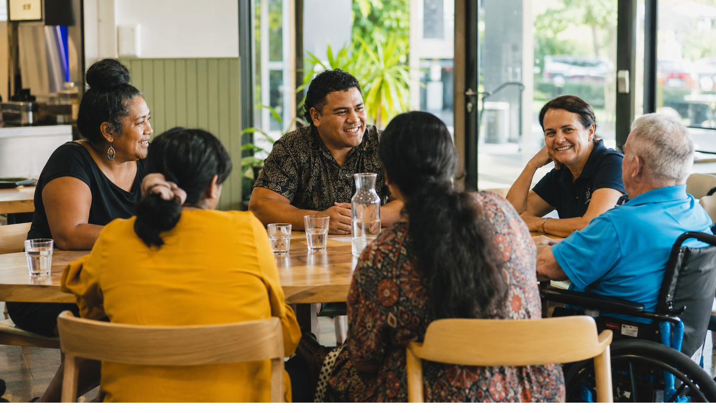 Participants and support workers sharing a meal and conversation